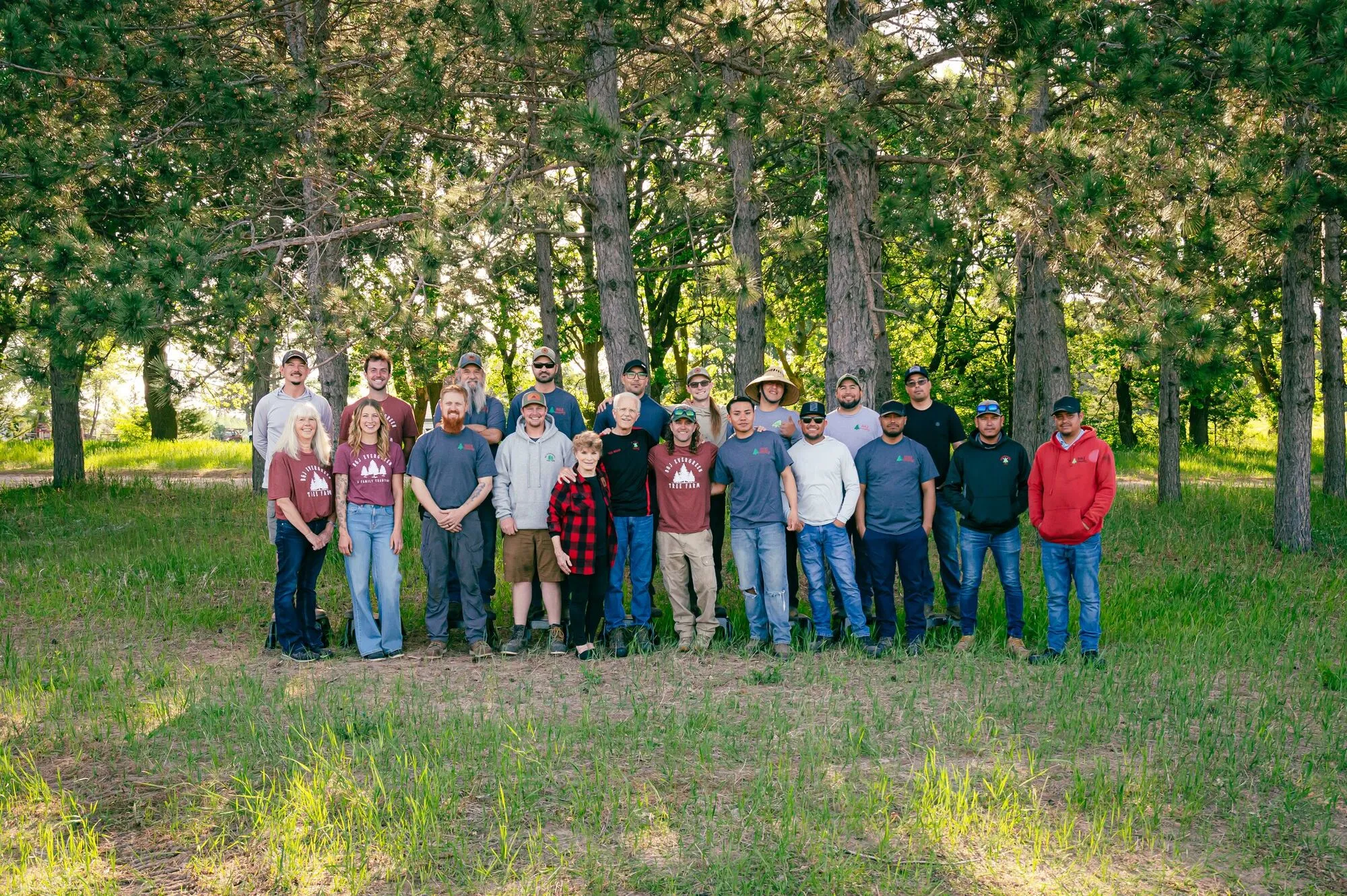 The 2026 B&J Evergreen crew with Brad and Mary Dean, lined up under the pines on spring picture day