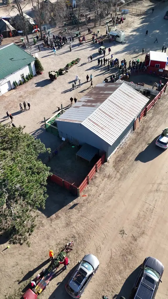 High aerial view of the farm buildings and a crowd of visitors during a free event weekend